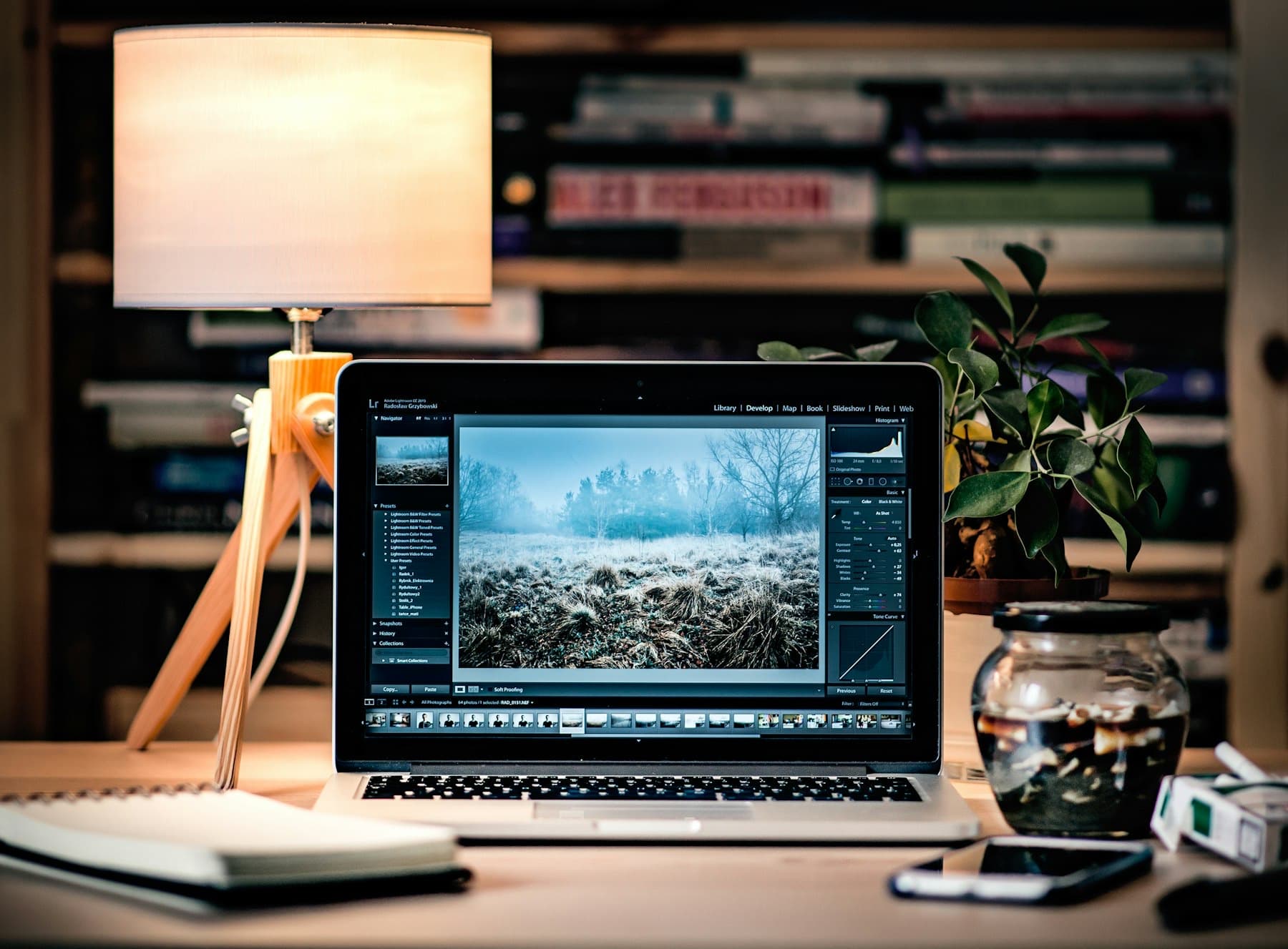 A designer's desk with a laptop and lamp