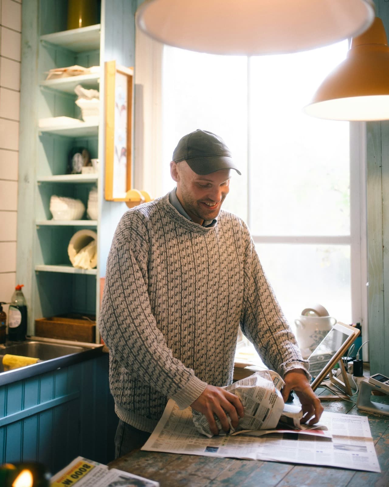 A shop owner wrapping an order by a window